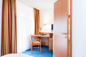 ein Hotelzimmer mit einem Stuhl und einem Schreibtisch in der Unterkunft Hydepark in Haidkapelle