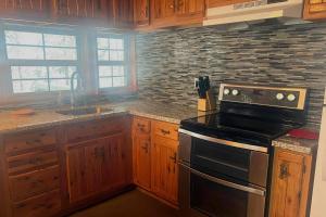 Una cocina con gabinetes de madera y un horno de estufa. en Snowball House, en Government Camp