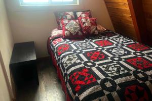 Un dormitorio con una cama con una colcha encima en Snowball House, en Government Camp