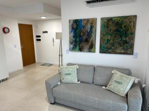 a living room with a couch and paintings on the wall at Metra Rosario lo mas alto para 4 in Rosario