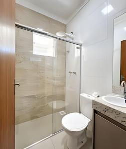 a bathroom with a shower and a toilet and a sink at 403-AP próx Unipam e Parq Expo-AR-Elevador-Garagem in Patos de Minas +22 photos