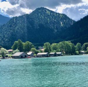 a large body of water with houses and a mountain at AlpenOase Schliersee - große Suite mit Sauna oder gemütliche Studio Appartements in Schliersee