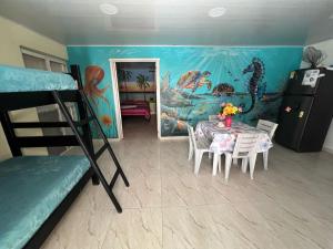 a room with a dining table and a mermaid mural at Bella Marcela in Buenavista