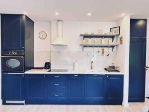a kitchen with blue cabinets and a sink at City Center Apartment in Gdańsk