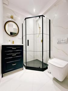 a bathroom with a glass shower and a toilet at City Center Apartment in Gdańsk