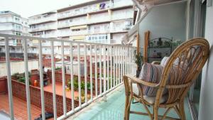 a balcony with a rocking chair and a view of a building at Apartamento Zepeling by Hr Costabrava in Platja  d'Aro