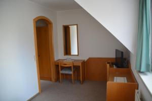 um quarto com uma secretária, um computador e um espelho. em Kronenwirt em Gurk