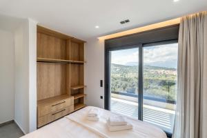 a bedroom with a bed and a large window at Villa Nefeli in Meganisi +26 photos