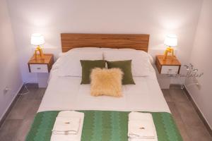 a large white bed with a brown pillow on it at EmBruHadas Relax in San Salvador de Jujuy