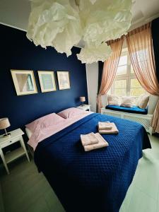 a bedroom with a blue bed with two towels on it at City Center Apartment in Gdańsk