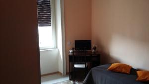 1 dormitorio con cama, escritorio y ventana en La Rosa dei Venti, en Salerno