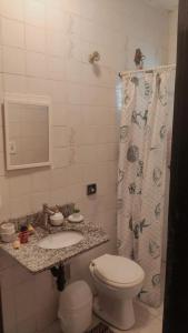 a bathroom with a toilet and a sink and a shower at Refúgio próximo as praias de Massaguaçu e Mococa in Caraguatatuba