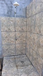 a shower with a stone tile wall with a light at Refúgio próximo as praias de Massaguaçu e Mococa in Caraguatatuba +17 photos