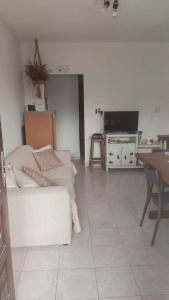 a living room with a couch and a tv at Refúgio próximo as praias de Massaguaçu e Mococa in Caraguatatuba