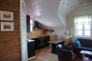 a kitchen and living room with a table and a couch at Aaroybukt Guesthouse in Årøybukta