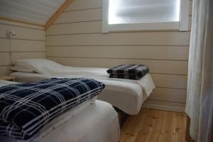 two beds in a room with a window at Aaroybukt Guesthouse in Årøybukta