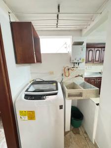 Una pequeña cocina con fregadero y refrigerador. en Apto 201 edificio parques del trianon, en Envigado