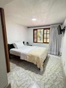 Un dormitorio con una cama grande y una ventana. en Apto 201 edificio parques del trianon, en Envigado