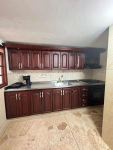 Una cocina con gabinetes de madera y un fregadero. en Apto 201 edificio parques del trianon, en Envigado