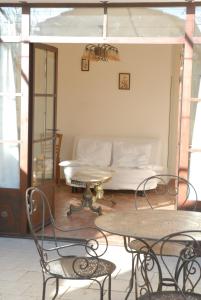 a living room with a bed and two tables and chairs at Gîte Du Mas Des Oliviers in Mézoargues
