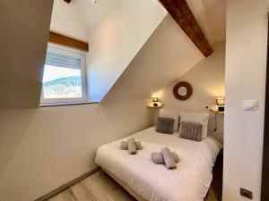 ein Schlafzimmer mit einem Bett mit zwei Kissen und einem Fenster in der Unterkunft Appart de Robert, nid de luxe au centre-ville in Gérardmer + 8 Fotos