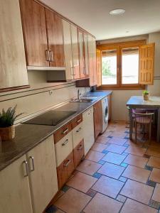 a kitchen with wooden cabinets and a tile floor at El palacio de Juana in Tordesillas