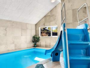an indoor swimming pool with a blue slide at 5 star holiday home in Dronningmølle in Dronningmølle