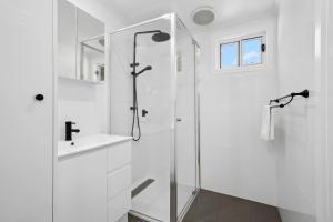 a white bathroom with a shower and a sink at Myrtleford Holiday Park in Myrtleford +64 photos