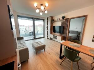 a living room with a dining table and a television at Summer Vibe Siófok - Wave in Siófok