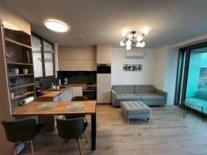 a kitchen and living room with a table and a couch at Summer Vibe Siófok - Wave in Siófok