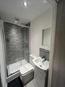 a bathroom with a toilet and a sink and a shower at Large 6 Bed 6 Bathroom House - Ideal For Families, Large Groups, Contractors & Business Travellers in Watford +15 photos