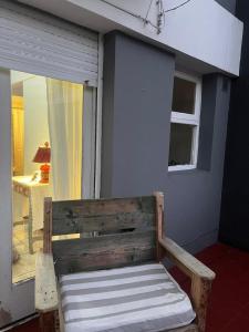 een houten bank voor een raam bij Alfonsina Departamento cerca del mar in Mar del Plata +33 foto's