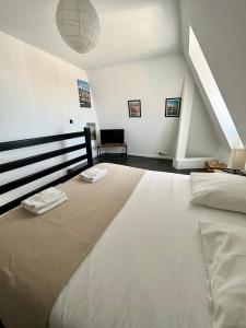 a large white bed in a room with a staircase at Un été sans fin à Deauville in Deauville