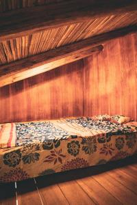 una cama en una habitación con una pared de madera en Casa de Mariano, en Otavalo