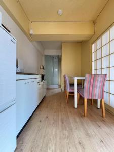 a kitchen with a table and two chairs at 海天ハウス花木303 in Beppu +16 photos