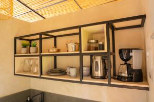 a shelf with pots and pans and a coffee maker at Tierra Mistú in Ginebra