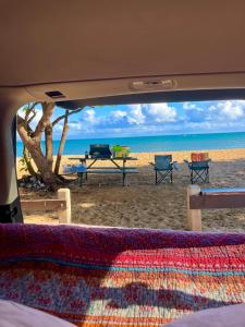 uma vista de uma praia com uma mesa e cadeiras em Campervan/Maui hosted by Go Camp Maui em Kihei