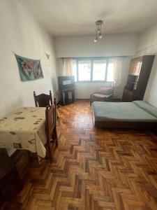 una stanza con due letti, un tavolo e delle sedie di Depto 1 amb Av Colon a Mar del Plata Altre 21 foto