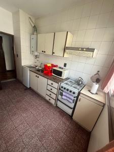 una piccola cucina con piano cottura e forno a microonde di Depto 1 amb Av Colon a Mar del Plata