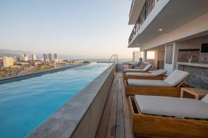a hotel swimming pool with a view of the city at Pool with ocean view, gym - grupoxingo in Puerto Vallarta
