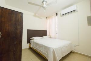 una camera da letto con un letto e un ventilatore a soffitto di Casa Dorada a Santa Cruz Huatulco