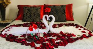 two swans laying on a bed covered in roses at Espaço Zen - Equilíbrio da Alma in Guarujá