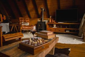 a living room with a couch and a tv at Cabana Alpina Ibitipoca in Conceição da Ibitipoca