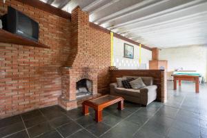 a brick room with a couch and a fireplace at Sítio Pousada Sol e Lua in Biritiba-Mirim
