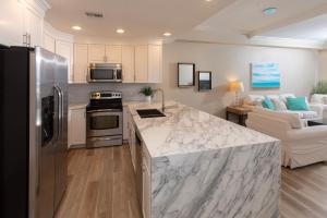 eine Küche mit Marmorarbeitsplatte und ein Wohnzimmer in der Unterkunft South Bay Beach Club #28 - 3Bedroom 2 Bathroom Unit in George Town