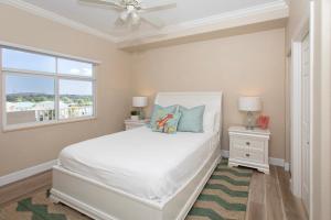 ein Schlafzimmer mit einem weißen Bett und einem Fenster in der Unterkunft South Bay Beach Club #28 - 3Bedroom 2 Bathroom Unit in George Town