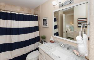 ein Badezimmer mit Waschbecken, Toilette und Spiegel in der Unterkunft South Bay Beach Club #28 - 3Bedroom 2 Bathroom Unit in George Town + 10 Fotos