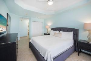 ein Schlafzimmer mit einem großen Bett und einem Fernseher in der Unterkunft South Bay Beach Club #30 - 3 Bedroom 2 Bathroom Unit in George Town