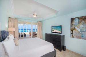 ein Schlafzimmer mit Bett und Blick auf das Meer in der Unterkunft South Bay Beach Club #30 - 3 Bedroom 2 Bathroom Unit in George Town