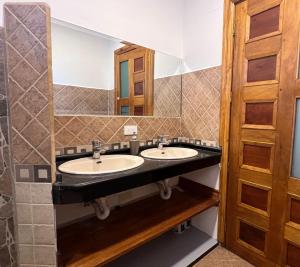 Un baño con dos lavabos y un espejo. en Villa Pastaza 4 Bedroom 3 Bath, en Baños